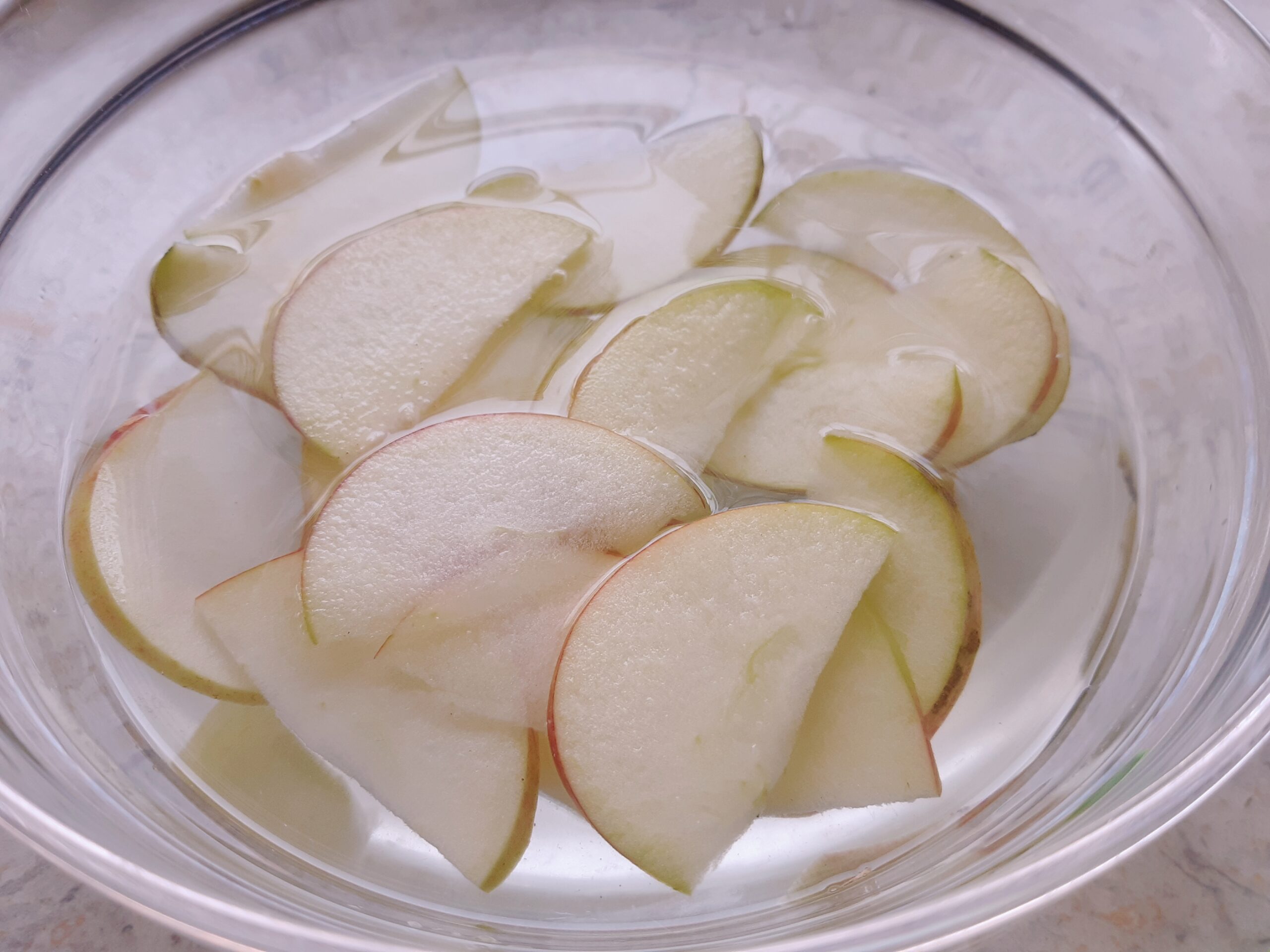 Schüssel Wasser mit Apfelscheiben